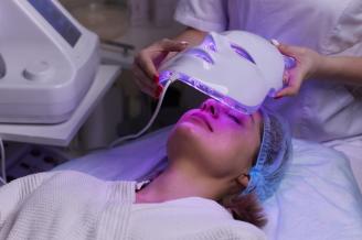 Una mujer durante un tratamiento con una máscara de luz LED.
