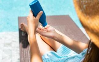 Una mujer se echa en la mano crema solar.