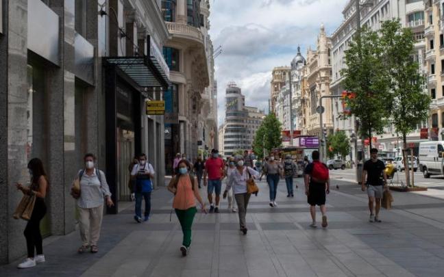Varias personas caminan por la Gran Vía con mascarilla Varias personas caminan por la Gran Vía con mascarilla