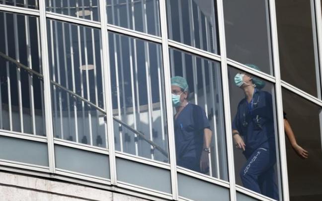 Dos médicos con mascarillas recorren el hospital Dos médicos con mascarillas recorren el hospital
