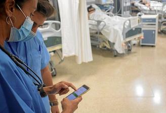 Varios sanitarios consultan datos en su móvil