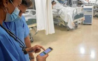 Varios sanitarios consultan datos en su móvil Varios sanitarios consultan datos en su móvil