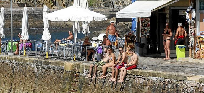 Gente descansando en la isla, junto al bar que solo abre en temporada de verano. Foto: Javi Colmenero