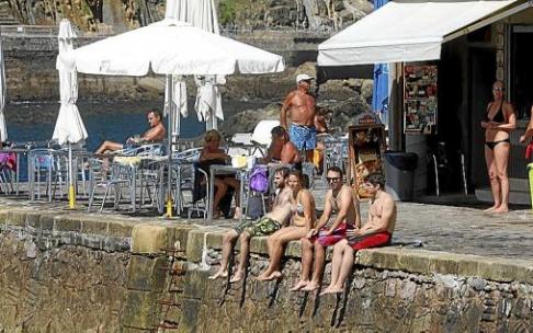 Gente descansando en la isla, junto al bar que solo abre en temporada de verano. Foto: Javi Colmenero