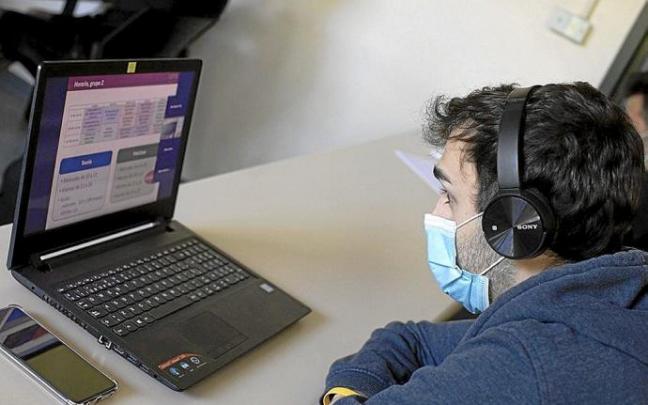 Artxiboko irudi batean, ordenagailu eramangarriari lotutako entzungailuak dituen gazte bat. Argazkia: DNA