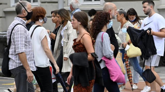 Varias personas pasean protegidas por la mascarilla