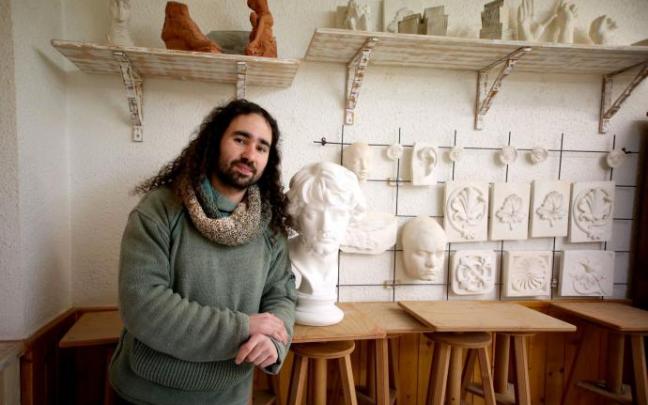 Yerai Paz Gómez posa junto a una escultura de barro.